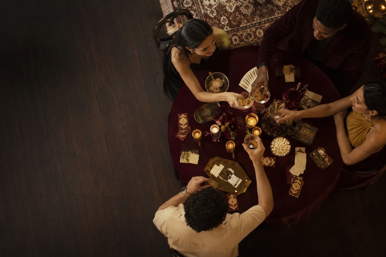 Overhead view of a set party table as guests reach for alcohol-free drinks and game cards
